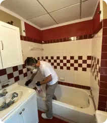a man wearing a mask and cleaning a bathtub